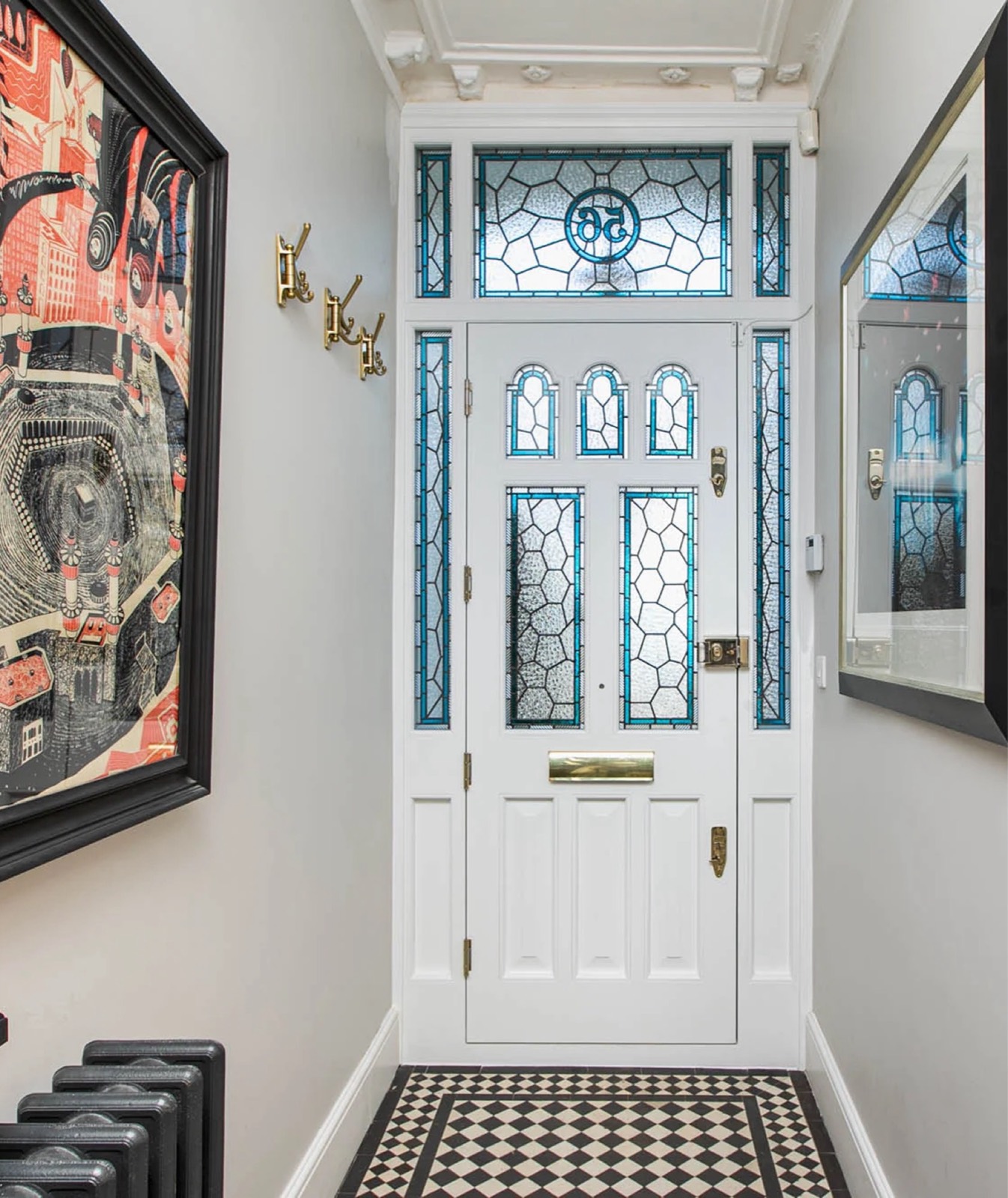 Bright hallway with a white panelled front door and stained-glass fanlight